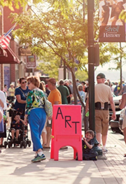 Streets view of pedestrians walking down Boyne City street